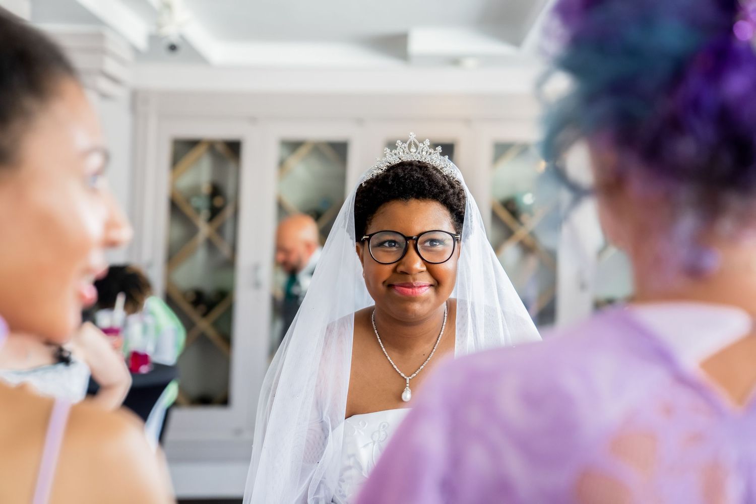 Wedding guests share joyful moments and laughter during an elegant celebration with purple decor accents.