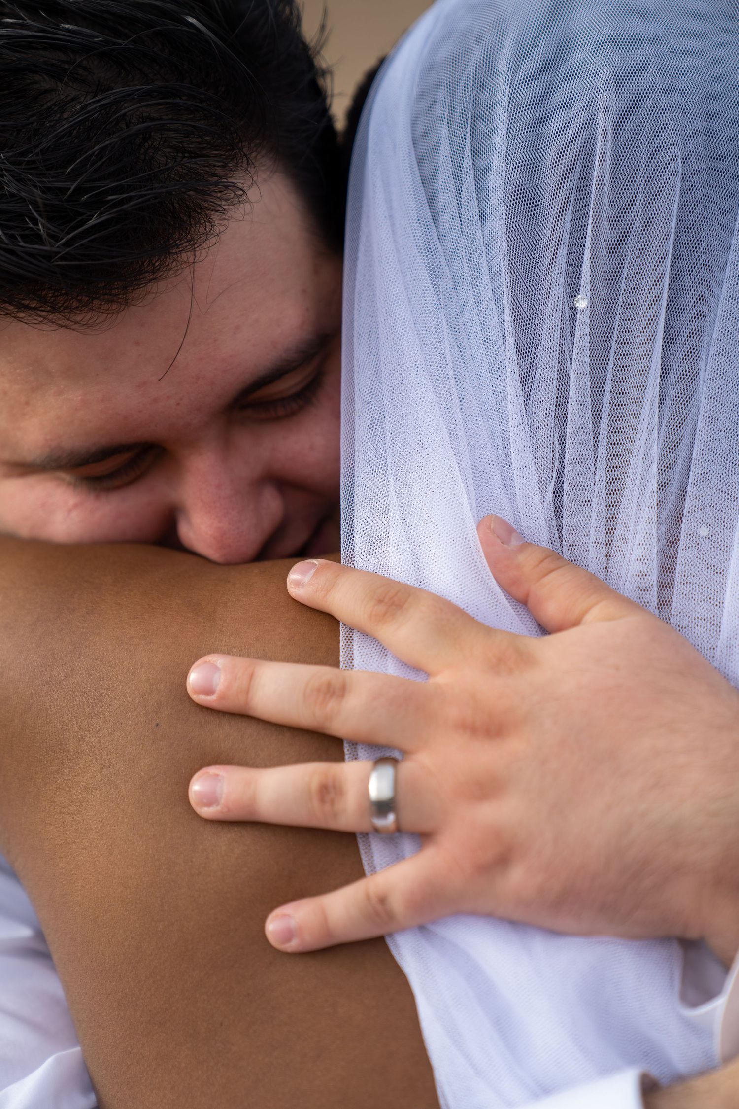A series of intimate photos showing hands wearing a wedding ring embracing in a tender moment.