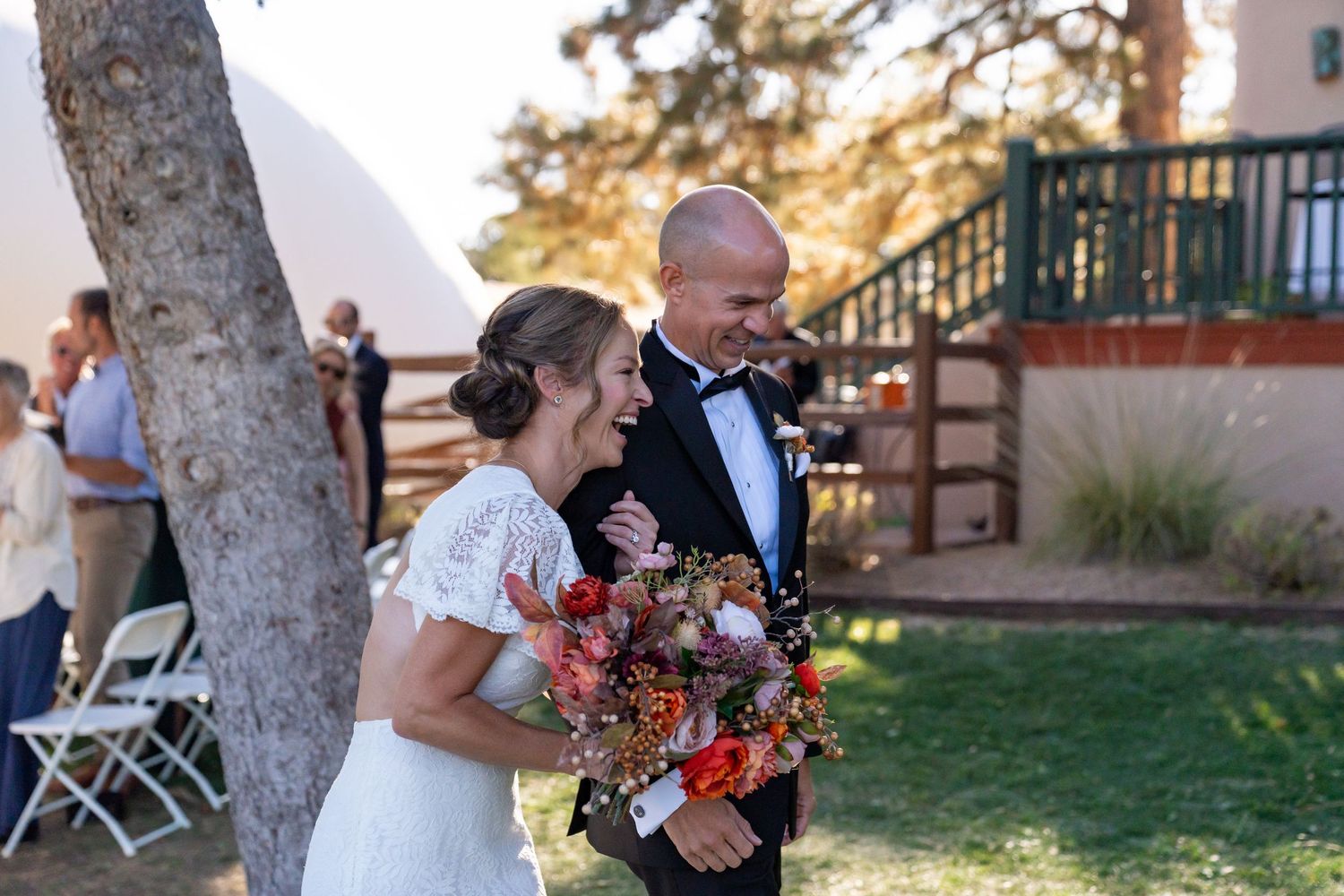 Wedding party gathers outdoors on a sunny autumn day.