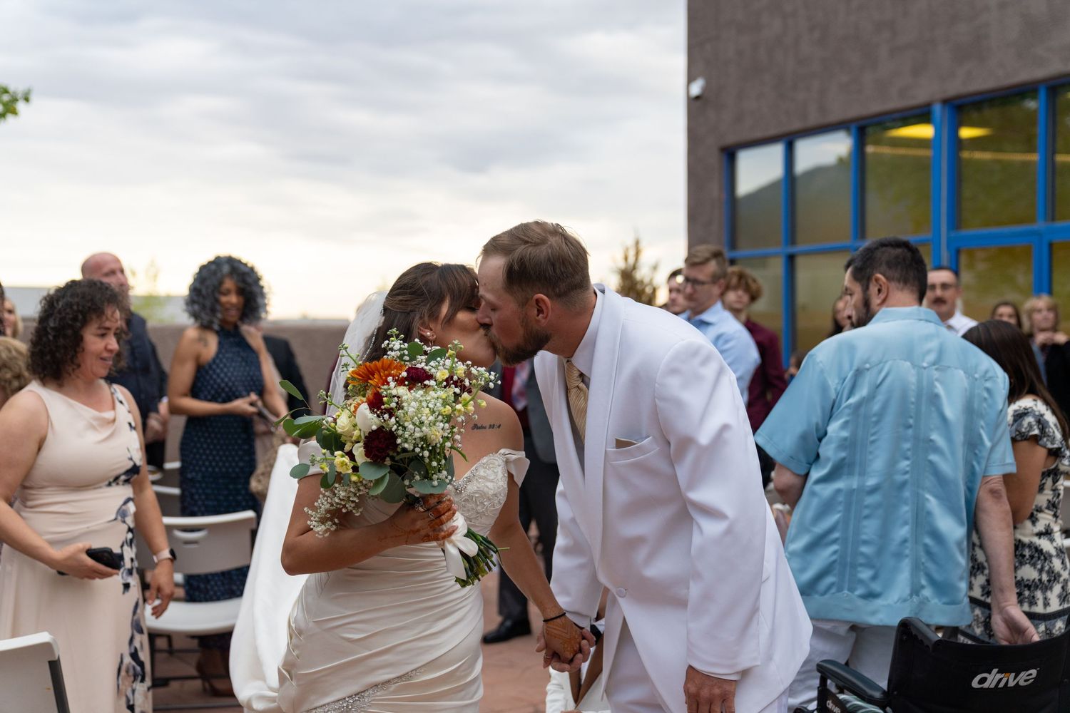Wedding celebration with guests dancing and enjoying festivities outdoors.