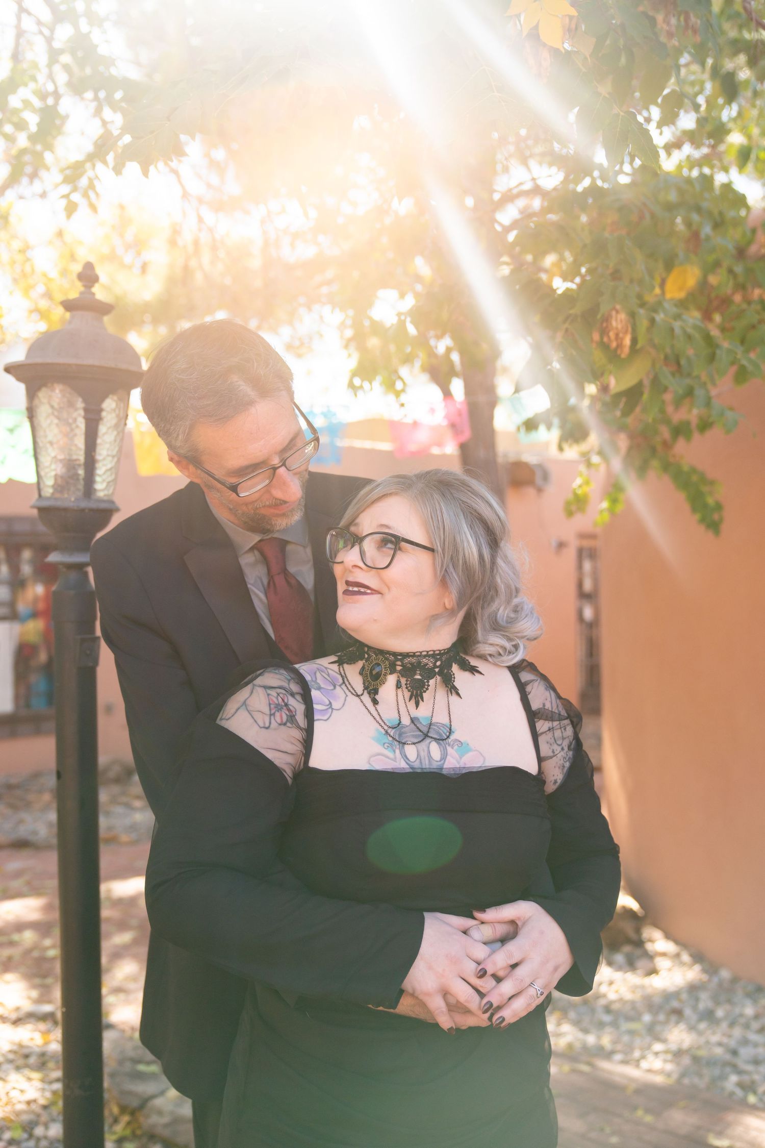 A joyful couple shares a laugh together in warm autumn sunlight.