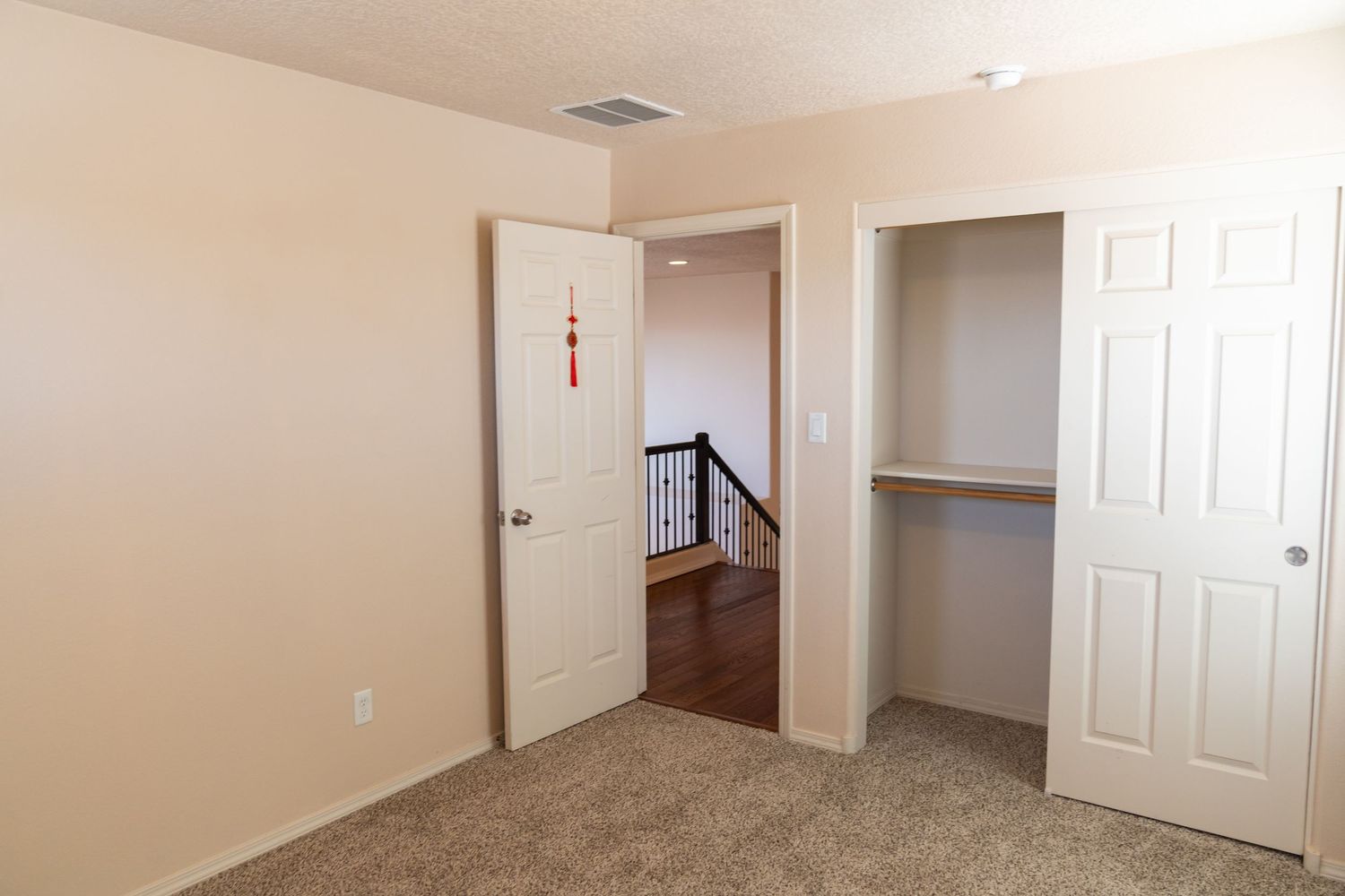 Empty beige-walled room with white doors and carpeted flooring shown from multiple angles.