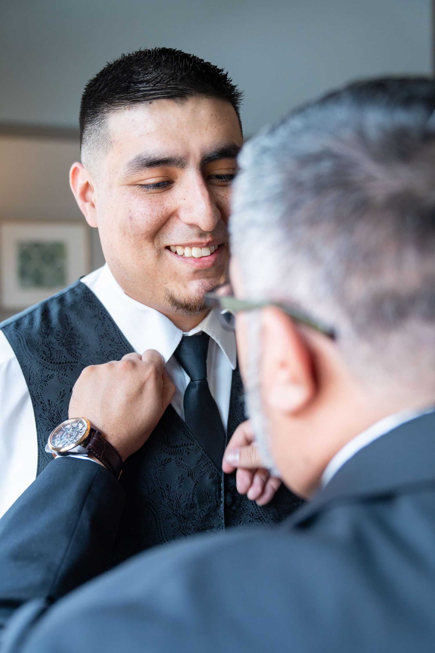 Close up candid moments between men in formal attire during a wedding.