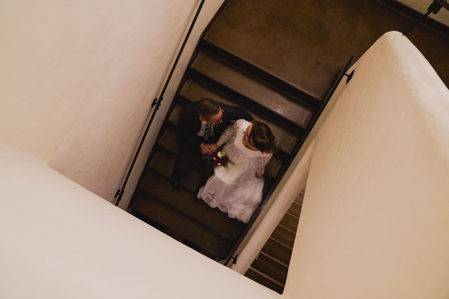 Wedding couple poses together in an elegant indoor setting with soft lighting and romantic atmosphere.