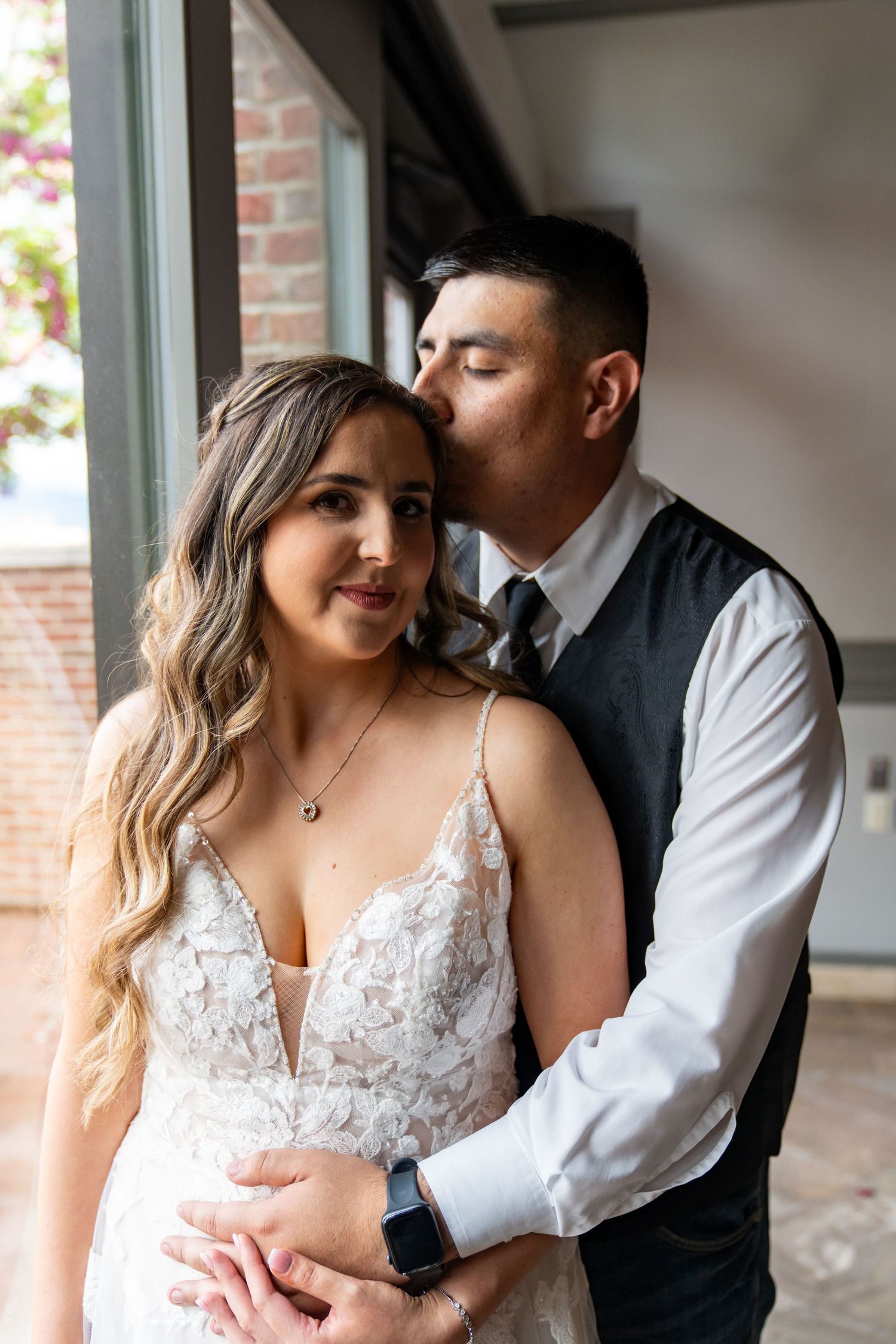 Romantic wedding portrait showing tender moment between newlyweds in formal attire.