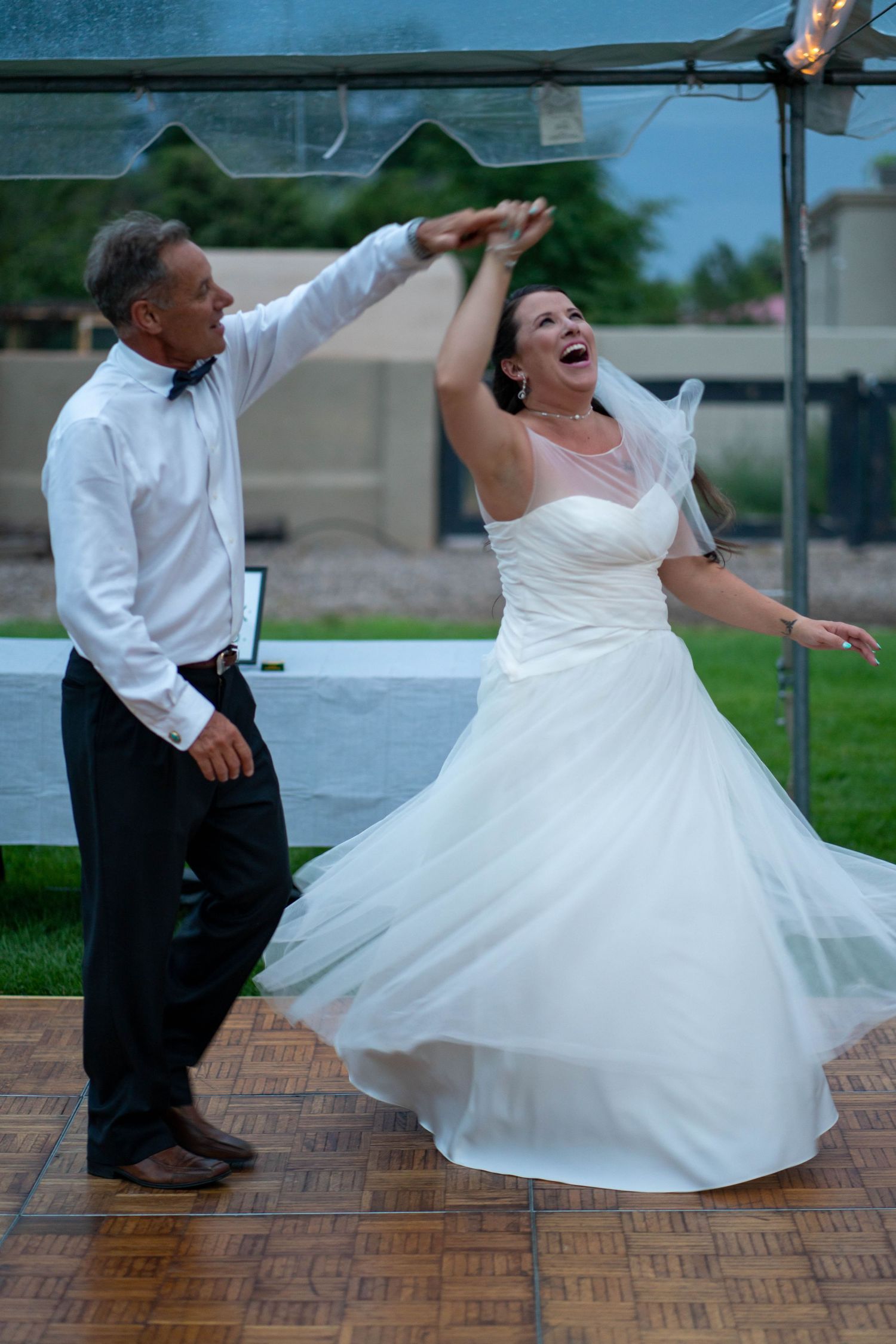 A sequence of playful wedding dance photos showing spins and dips on a brick patio.