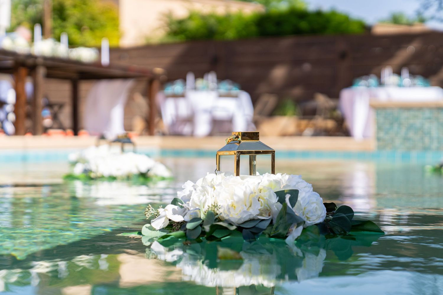 White lotus flowers and lily pads float serenely on the tranquil surface of a pool.