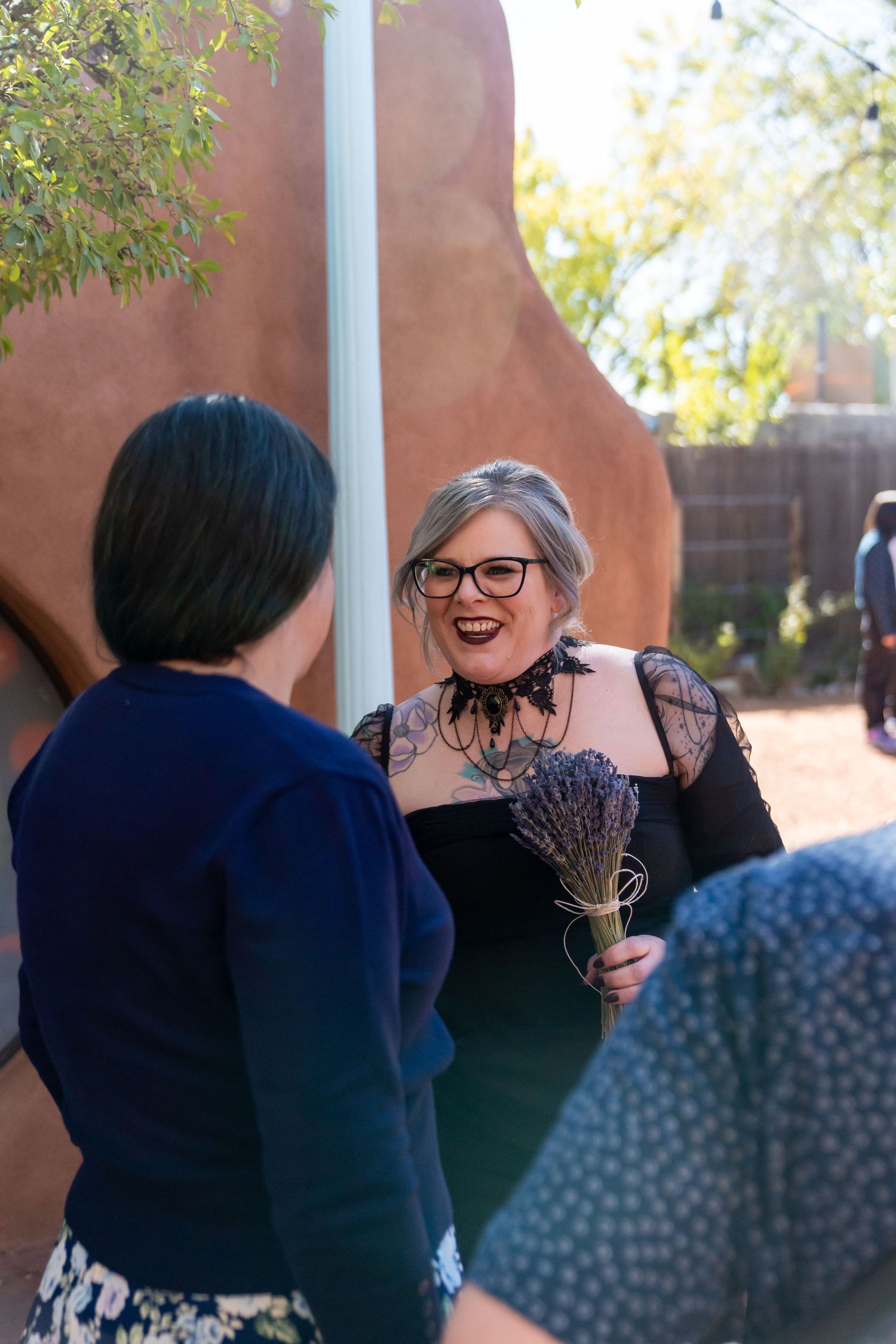 A tender moment shared between two people in front of an adobe-style wall.