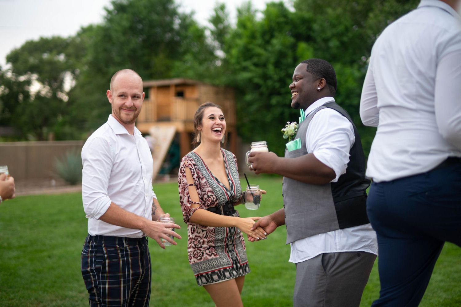 A group of friends laughing and socializing together at an outdoor garden party.