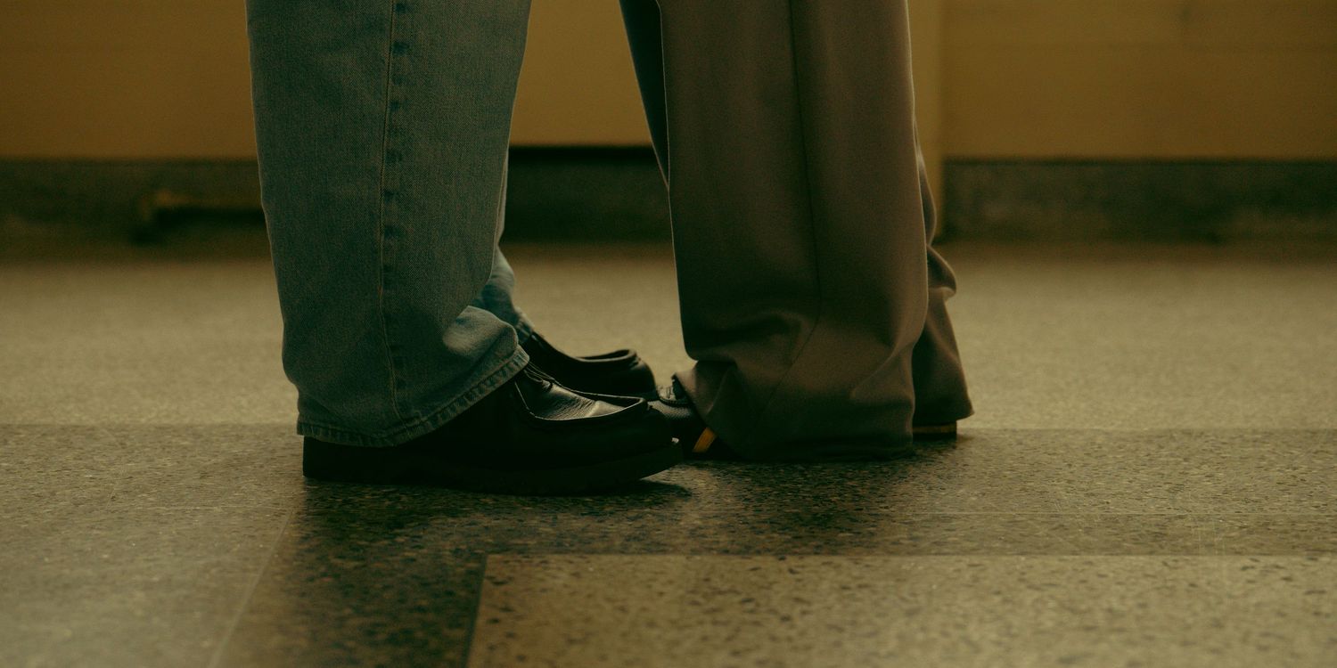 People sitting close together on a floor in muted lighting conditions.