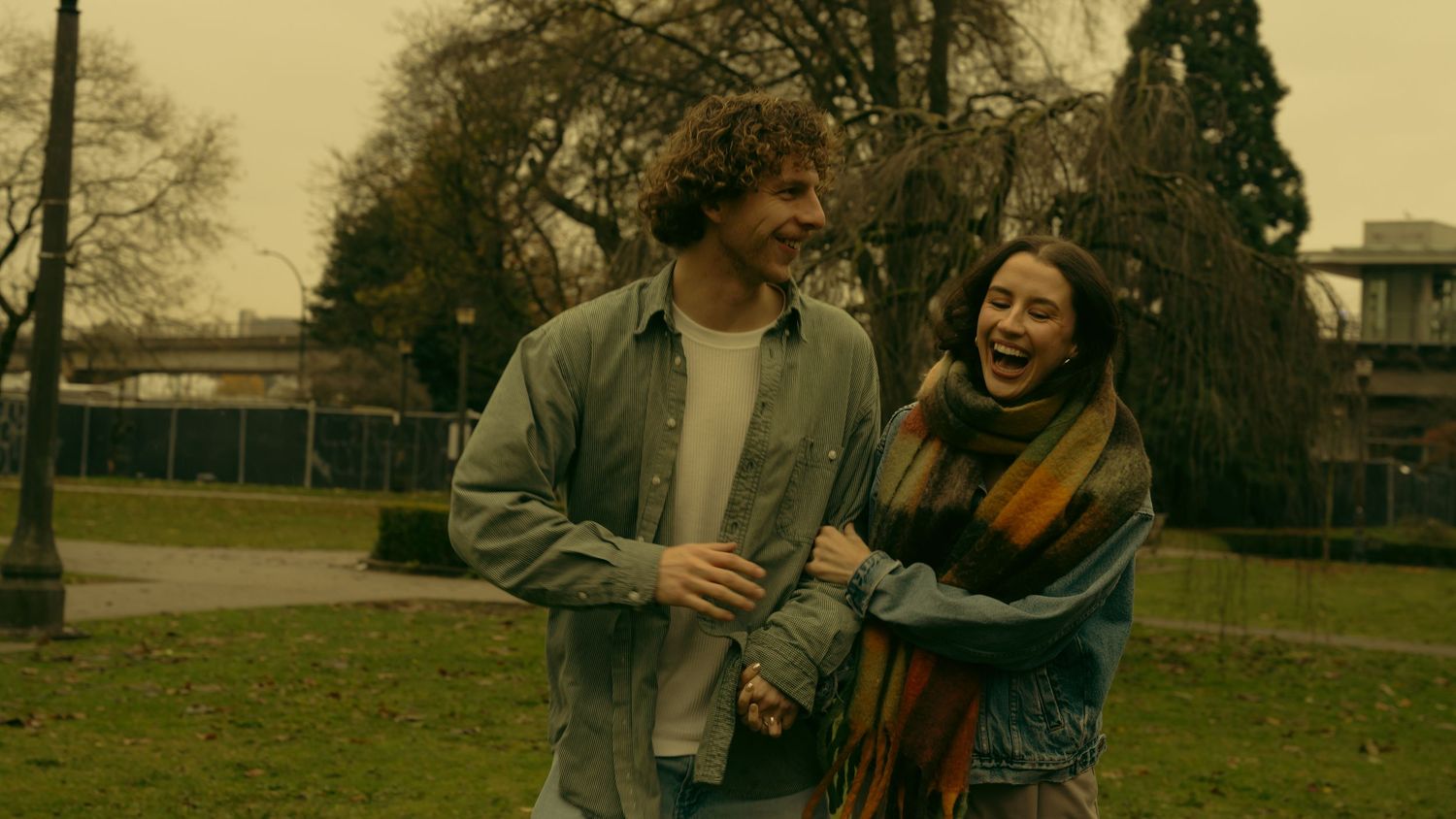Friends enjoying a casual moment together in a park during fall season.