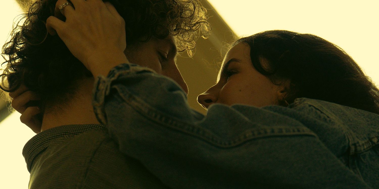Silhouettes of people against a warm yellow background in an intimate scene.