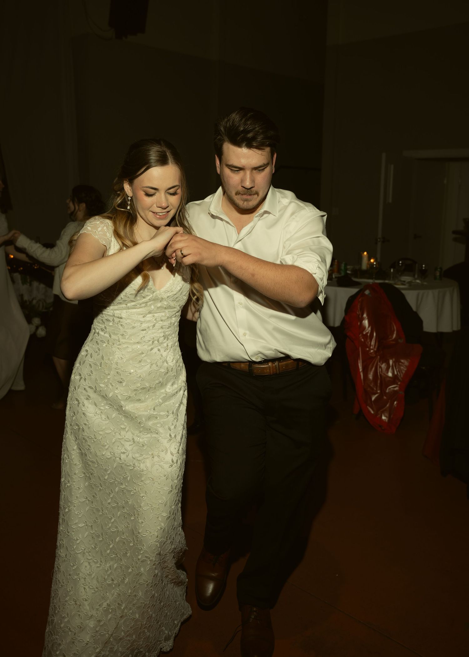Couple dancing together at wedding reception in formal attire.