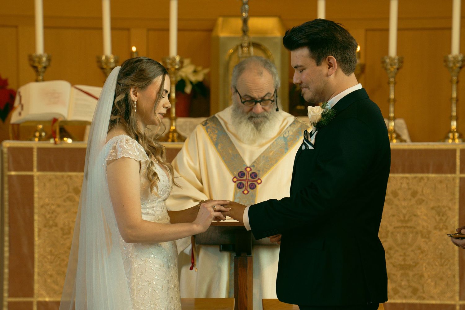 Wedding ceremony in a church with ornate candelabras and traditional decor.