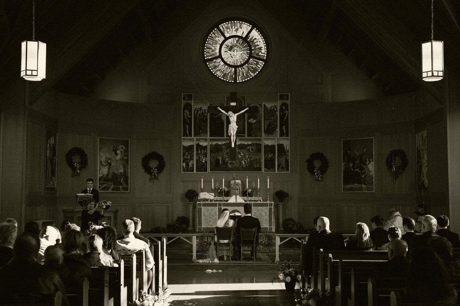Dark and moody church ceremony captured in dramatic black and white photography.