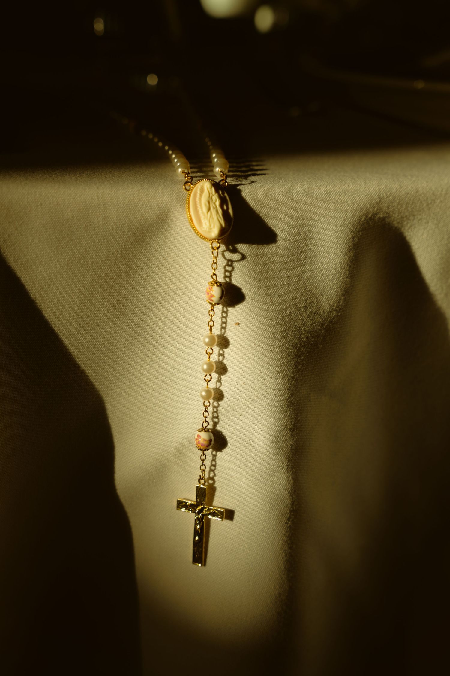 A decorative golden key pendant hanging in dramatic lighting against a dark background.