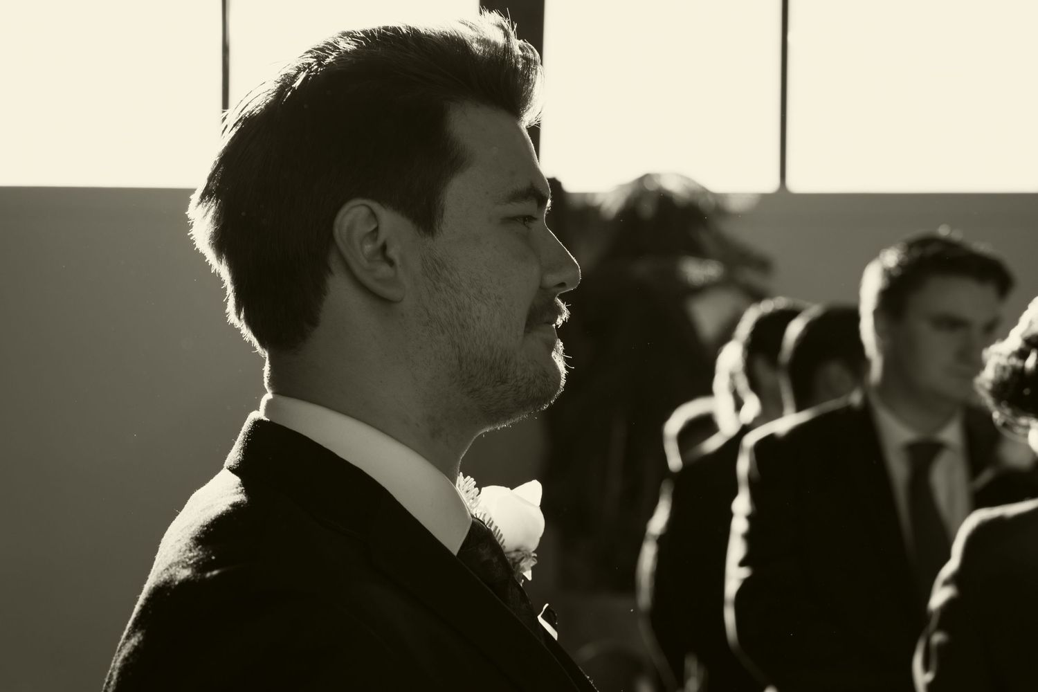 Silhouettes of wedding guests in a dimly lit reception venue.