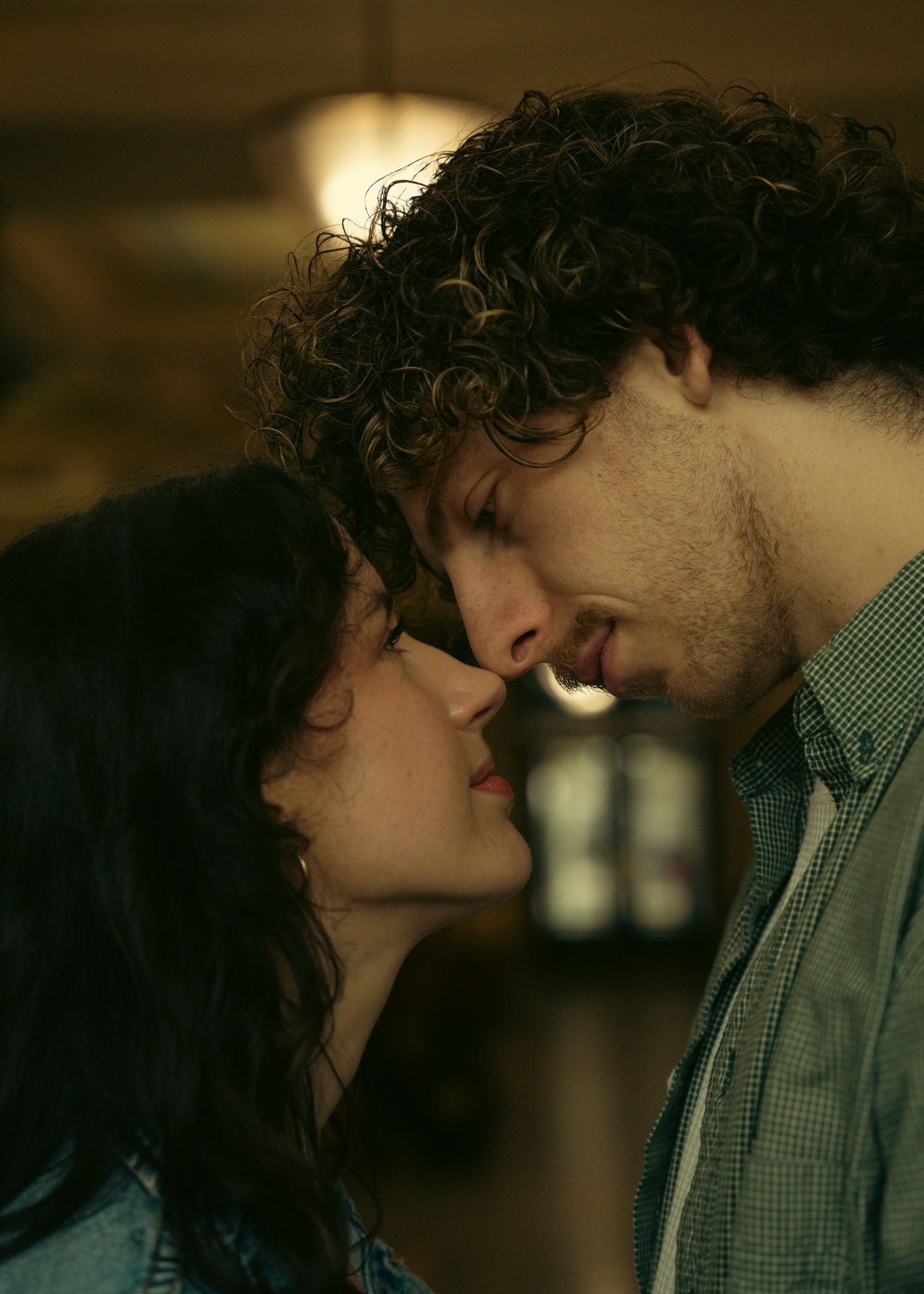 Romantic scene captured in warm, moody lighting with soft focus.