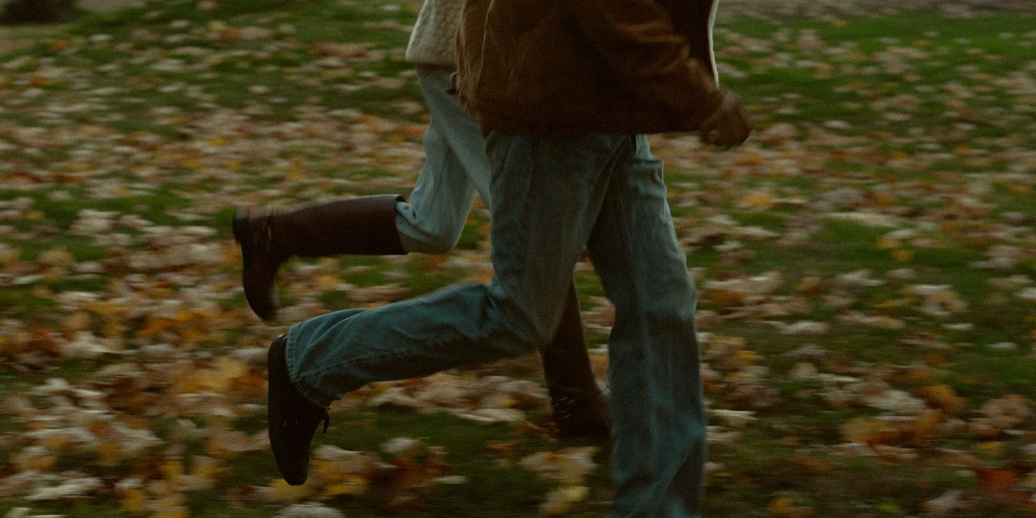 Group walking across leaf-covered ground during fall season.