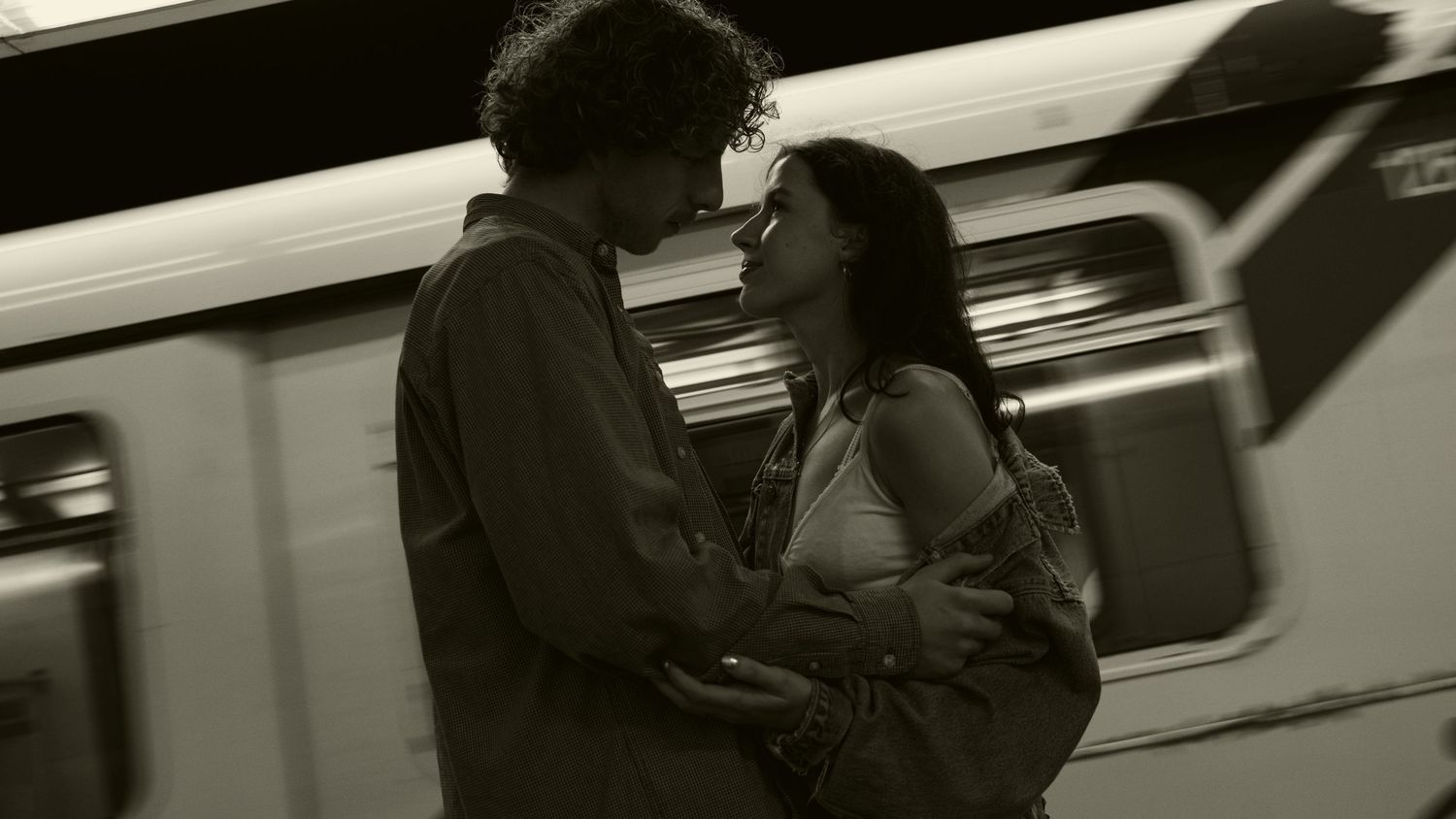 Blurred figures in motion near a passing subway train creating a dramatic composition.