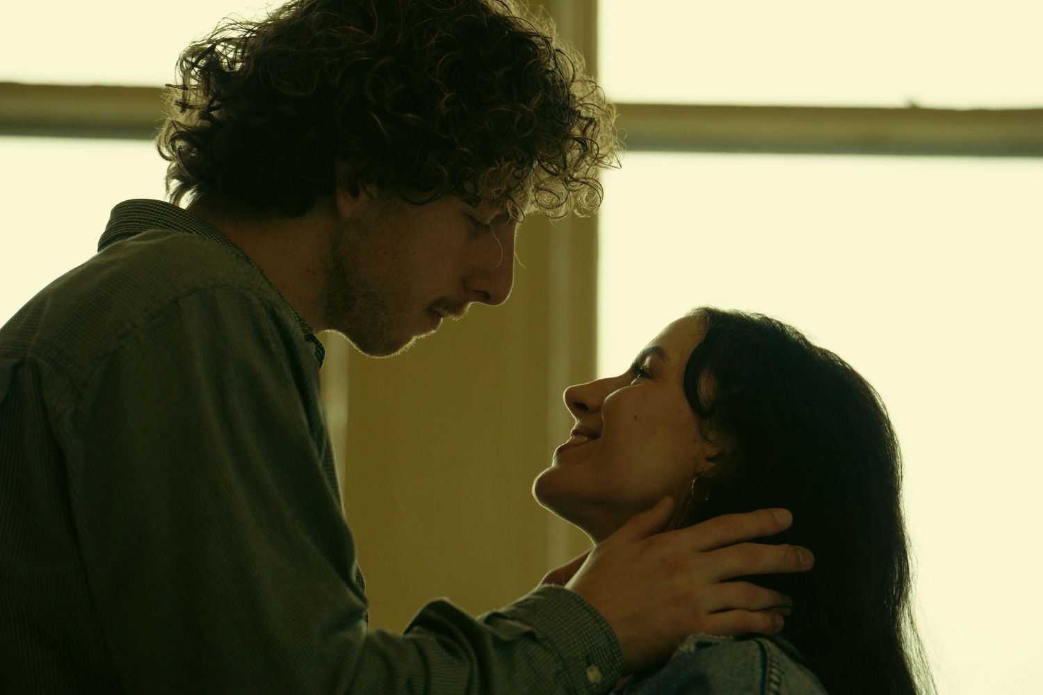 Two figures in close proximity with dramatic lighting creating a romantic atmosphere.