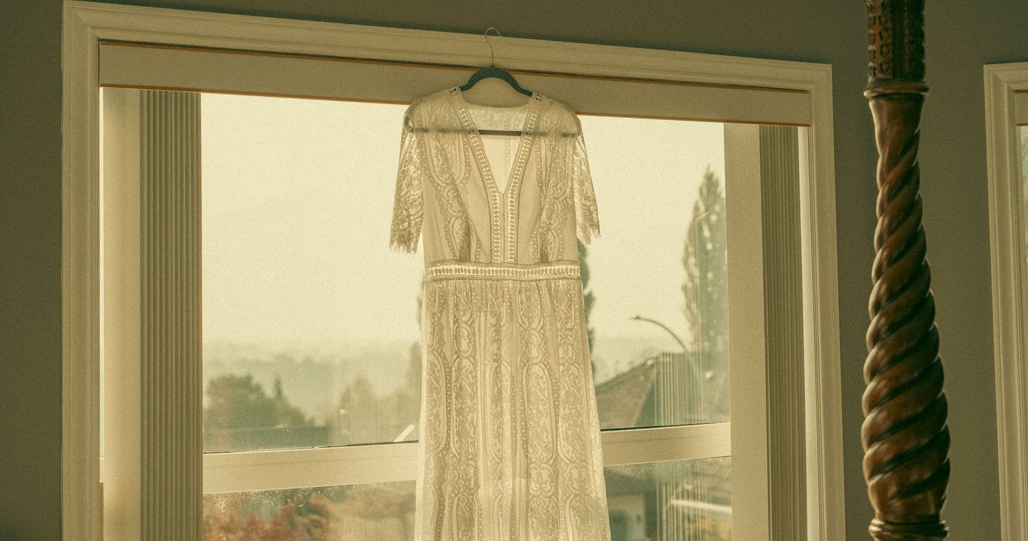 A vintage-style sepia photograph showing multiple wedding dresses displayed in a bridal shop window.