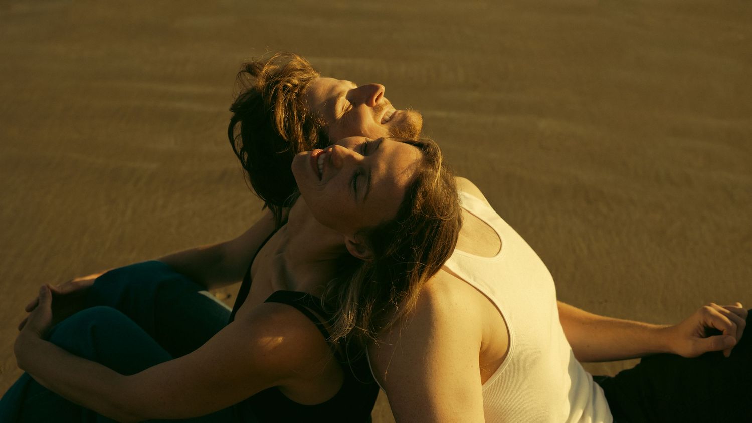 Two people share an intimate moment in warm golden lighting.