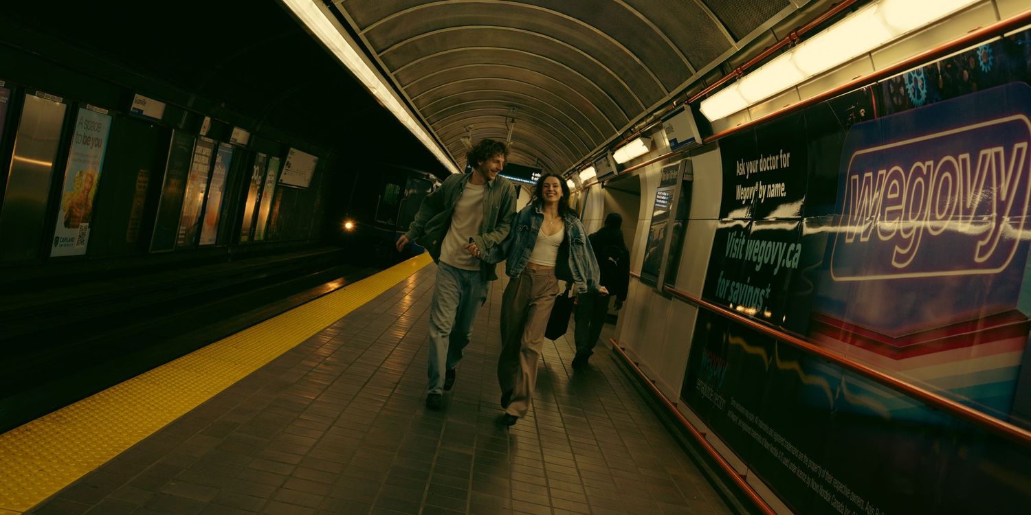 An empty subway platform with fluorescent lighting and curved tunnel walls.