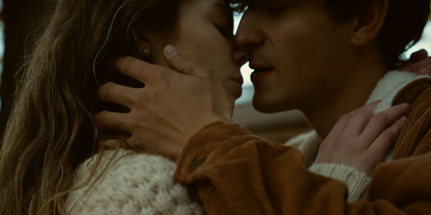 Close up of tender embrace between two people in soft lighting.