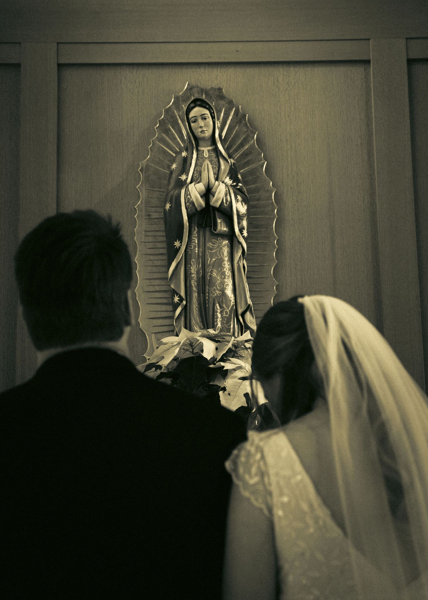 A sequence of six black and white photos showing a figure in a veil standing in front of a religious statue.
