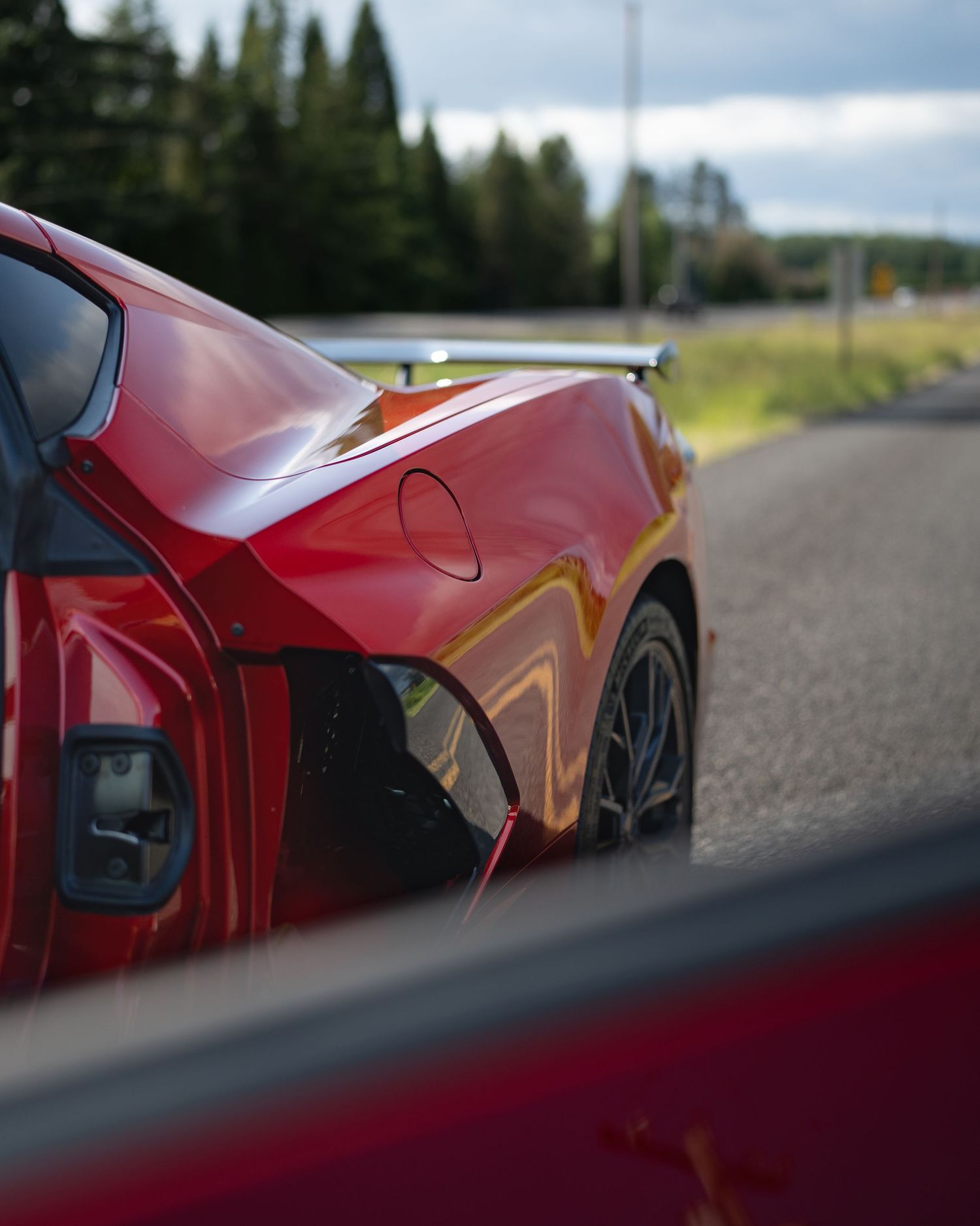 Side profile of a red sports car photographed at a dramatic low angle.