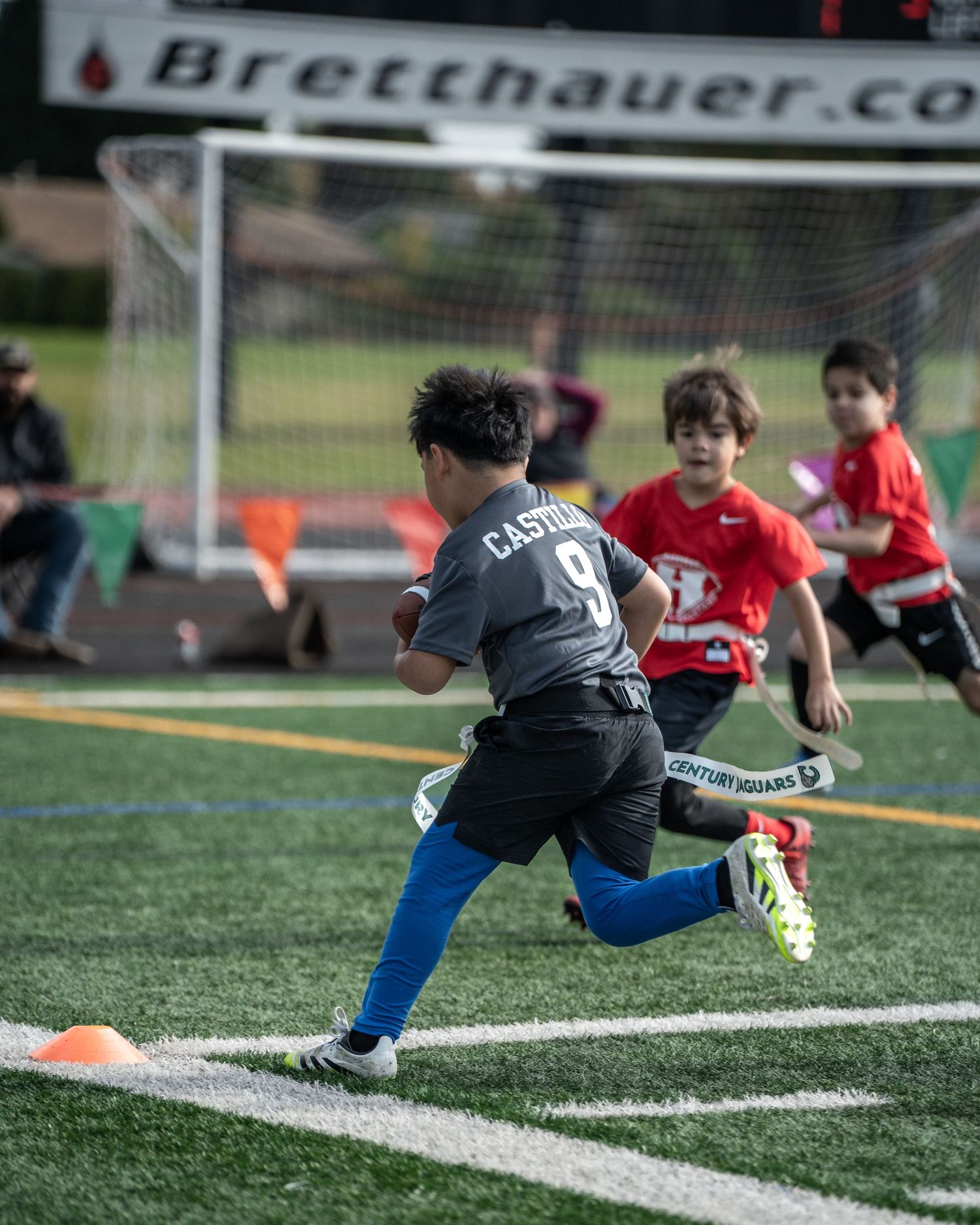Athletes perform diving exercises on an artificial turf field with white boundary lines.