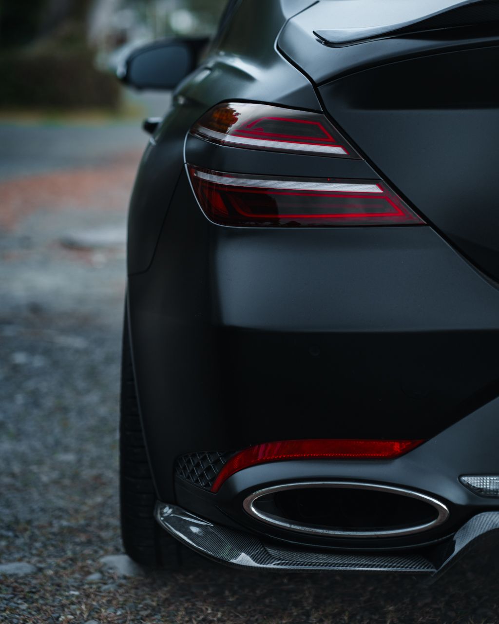 Sleek black sports car rear end with LED taillights and aggressive styling elements.