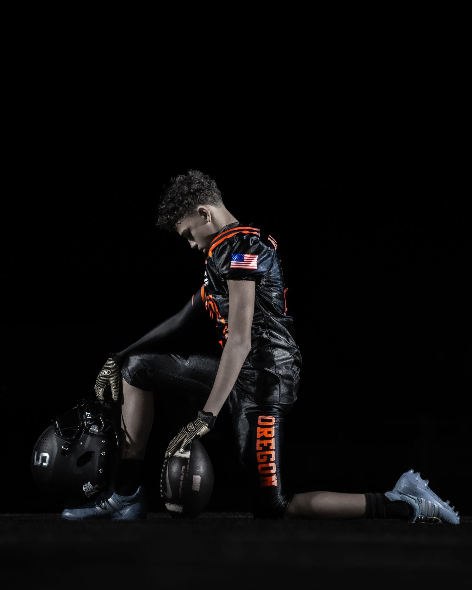 Four dark moody product shots of black sports gear and equipment against a black background with dramatic lighting.