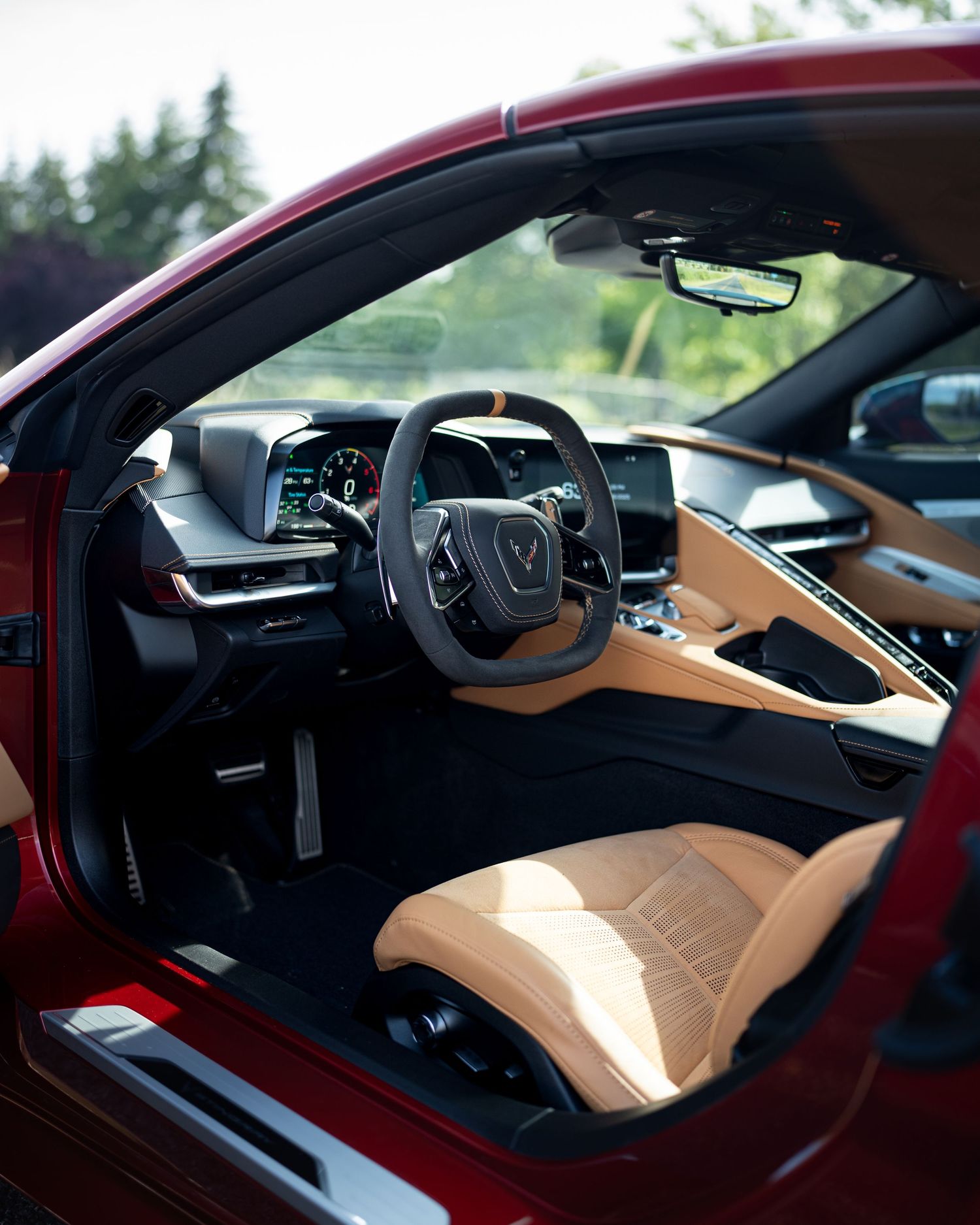 Modern dashboard and cockpit view of a luxury sports car with tan leather interior.