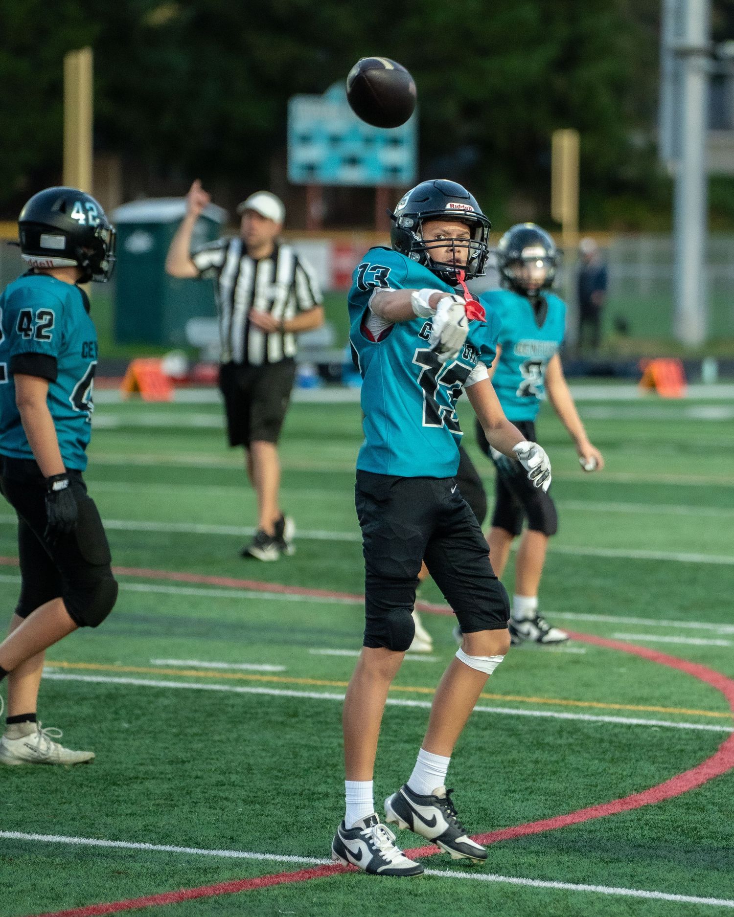 Football players practice field goal kicking drills on the turf.