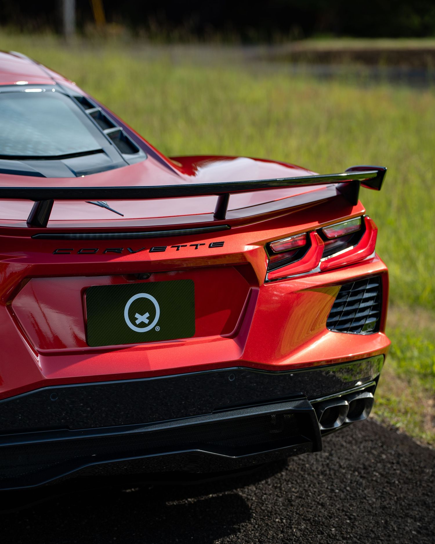 Rear view of a red sports car showing aerodynamic spoiler and LED taillights.