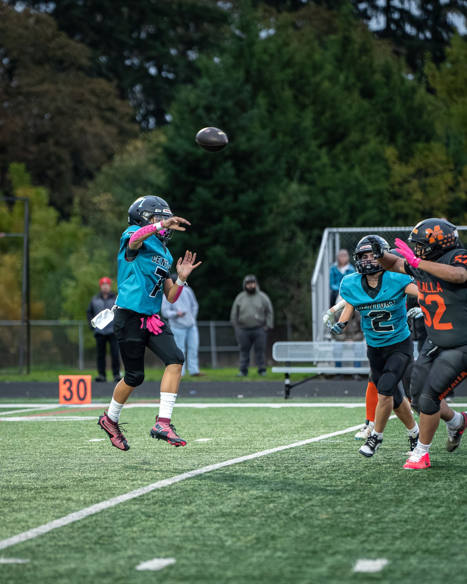 Athletes dive and stretch during football practice drill on artificial turf.