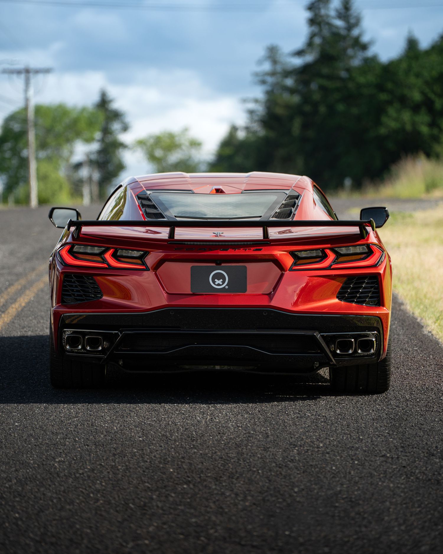 Wide rear view of a red sports car showcasing its aggressive stance and dual exhaust system.