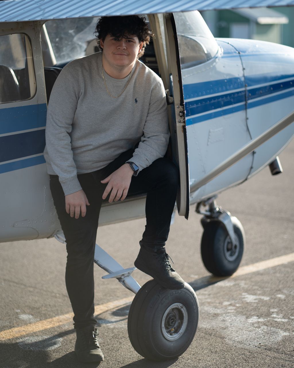 Close-up view of small aircraft landing gear and steps on tarmac.