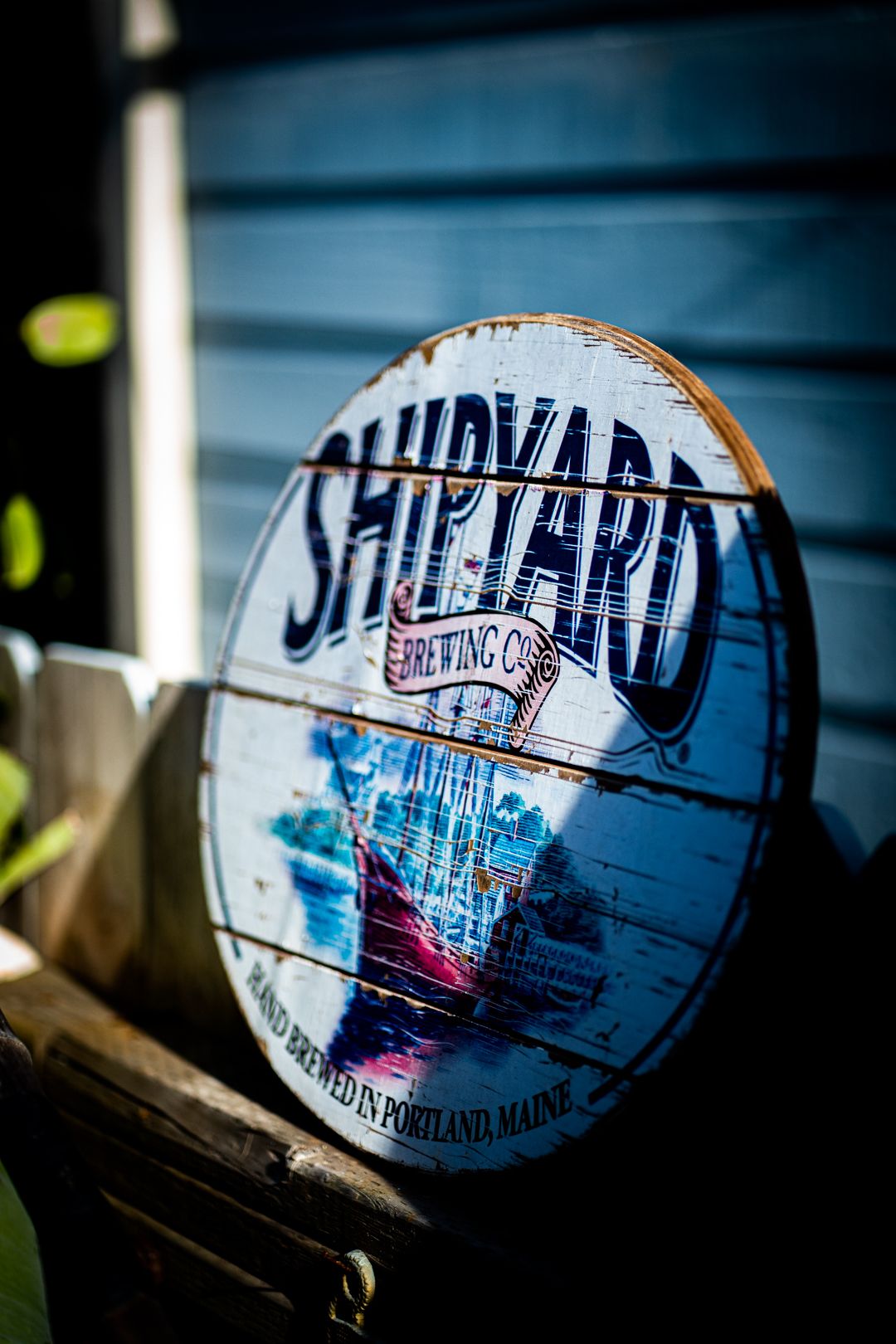 Vintage Shipyard Brewing Company logo on weathered surface with blue tones.
