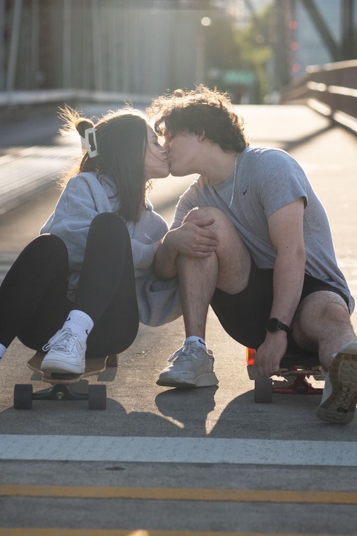 Two people crouching on a concrete surface in golden sunlight.