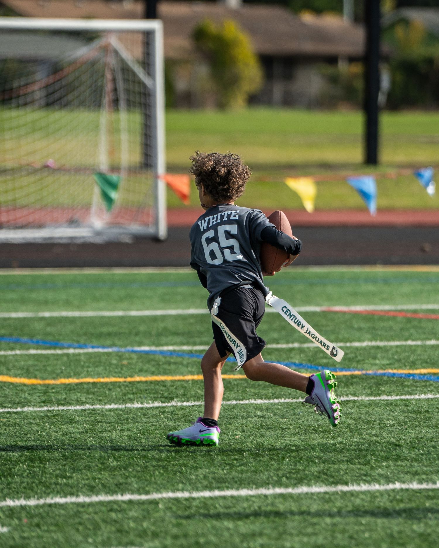 Youth athlete practicing diving catches during football training.