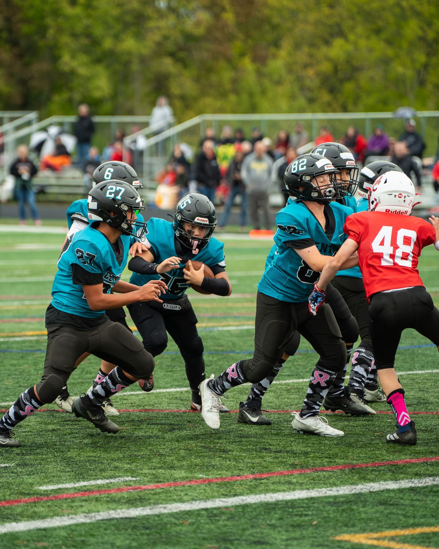 Football players from opposing teams crouch at the line of scrimmage ready for the snap.