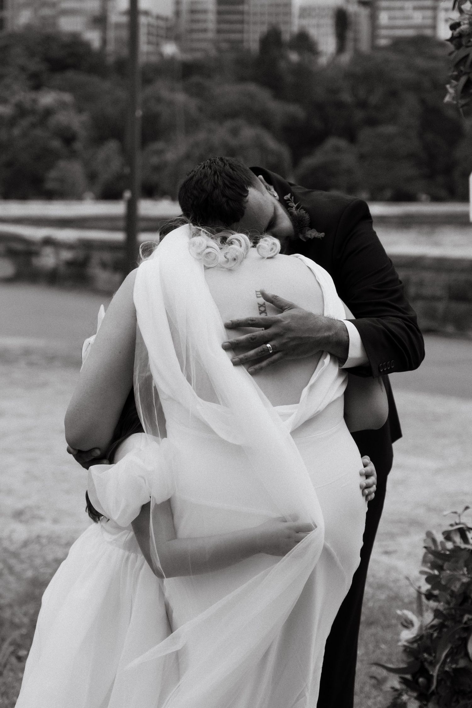 A black and white sequence of romantic wedding photos showing intimate embraces between a couple in formal attire.