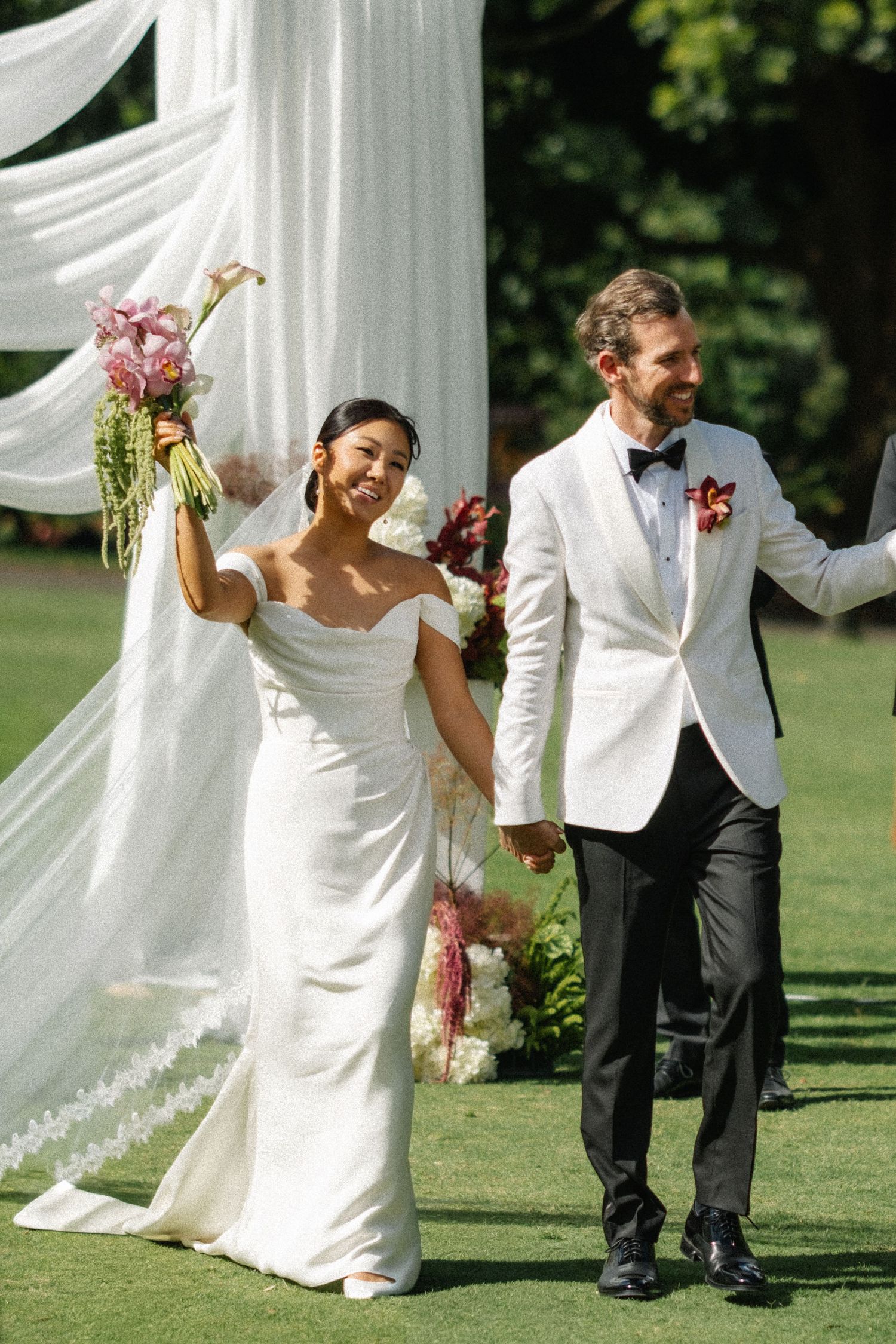 A series of candid wedding photos showing a couple in white and black attire dancing and laughing together outdoors.
