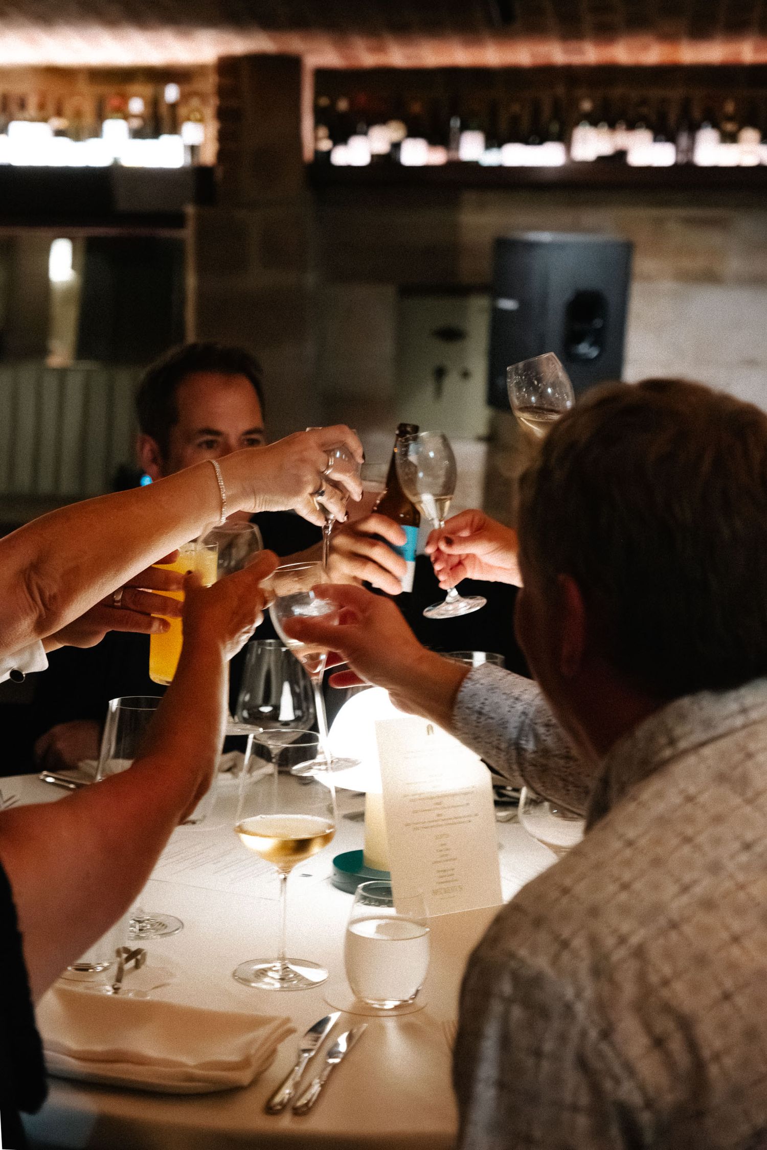 Four sequential photos show diners at a restaurant table examining their menus in dim lighting.
