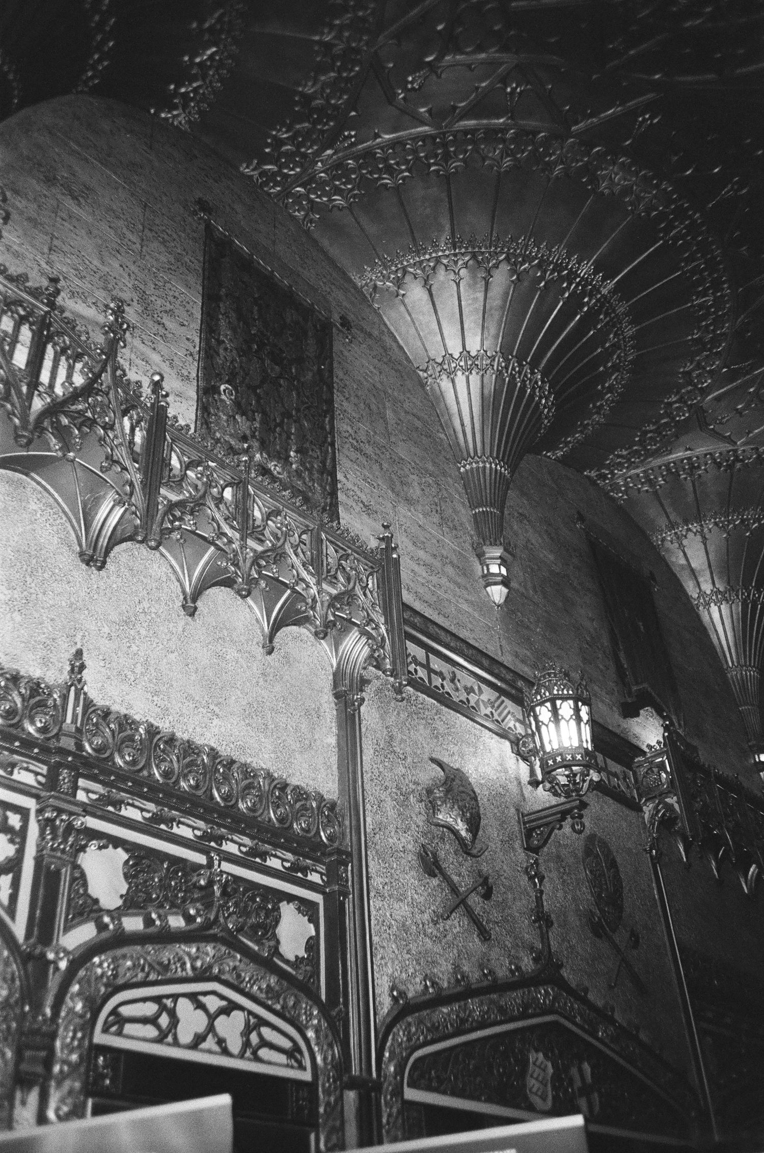 Art deco ceiling details with ornate metalwork and decorative light fixtures in a vintage theater or cinema.