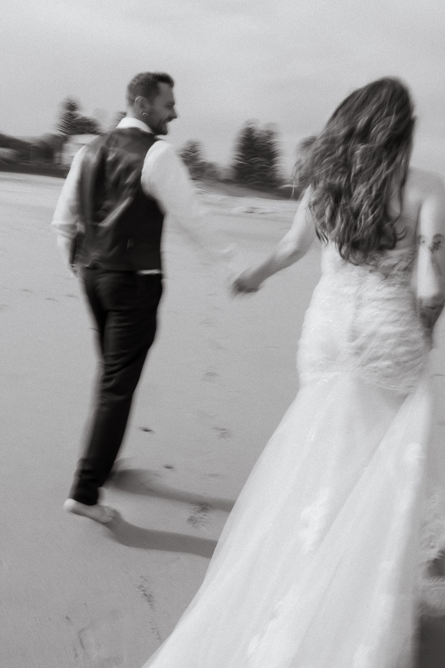 A black and white sequence of a bride and groom dancing together on a beach, creating a blurred motion effect.