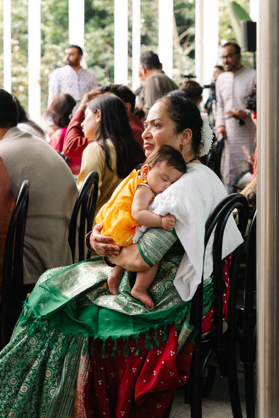 People in traditional green and red dresses dance and celebrate at a cultural festival gathering.